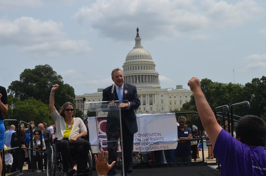 U.S. Senator Dick Durbin (D-IL) spoke at the 2014 Annual Rally for the National Council on Independent Living to urge for disability equality. Durbin praised the Workforce Investment Opportunity Act and called for the Senate to pass the UN Convention on the Rights of Persons with Disabilities. Seated in the yellow shirt beside Durbin is Marca Bristo of Illinois, a national leader in the Independent Living Movement.